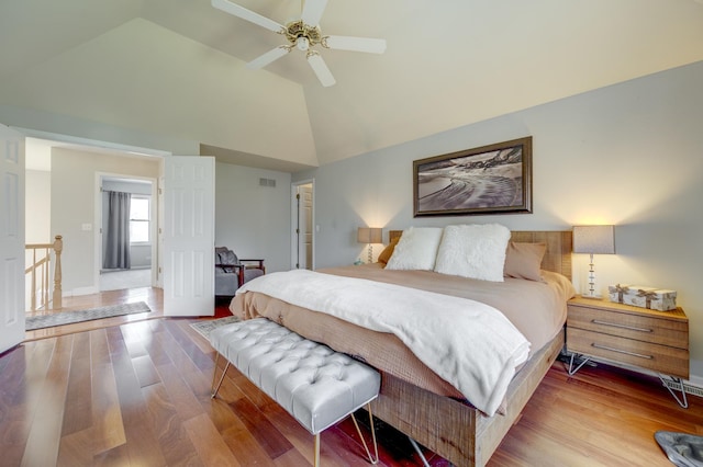 bedroom featuring ceiling fan, visible vents, wood finished floors, high vaulted ceiling, and baseboards