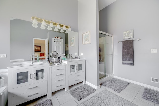 bathroom featuring a high ceiling, a shower stall, tile patterned flooring, and vanity