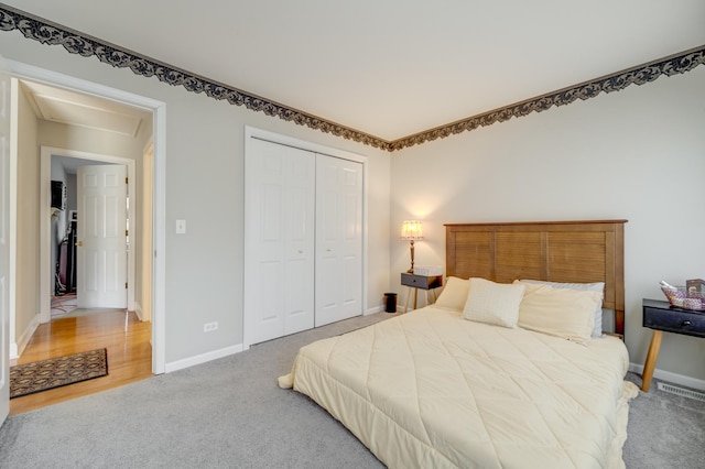 bedroom featuring baseboards, light carpet, a closet, and visible vents
