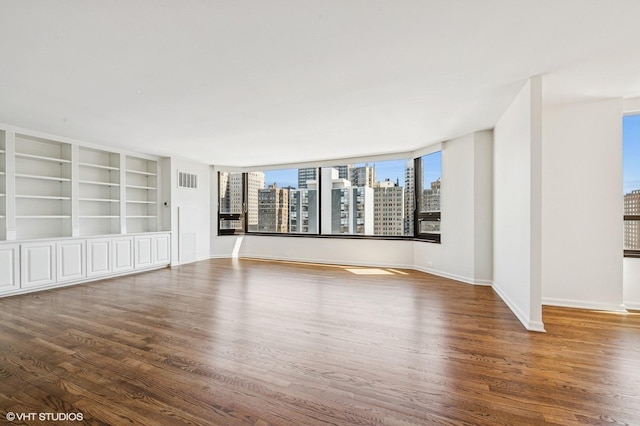 1410 N State Pkwy Unit 17B, Chicago, IL 60610 - empty room featuring wood finished floors, a skyline view, and built in shelves