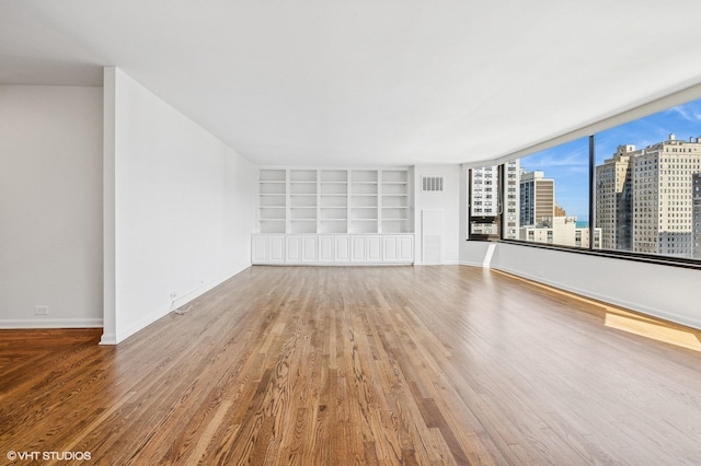 1410 N State Pkwy Unit 17B, Chicago, IL 60610 - empty room featuring wood finished floors, built in shelves, and a view of city