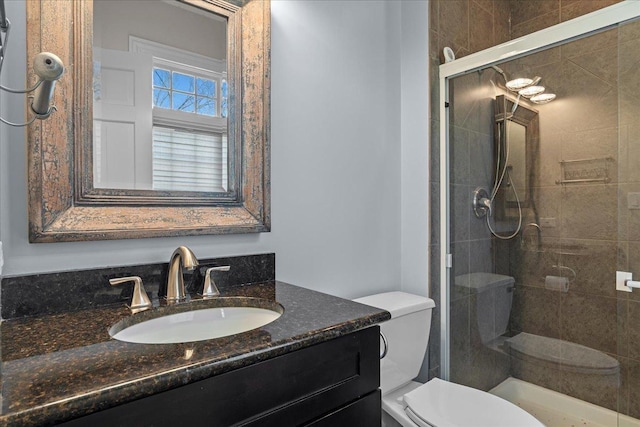 full bathroom featuring vanity, a stall shower, and toilet