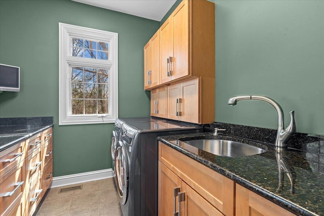 laundry area with visible vents, cabinet space, a sink, baseboards, and washer and dryer