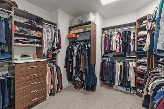 walk in closet featuring light colored carpet