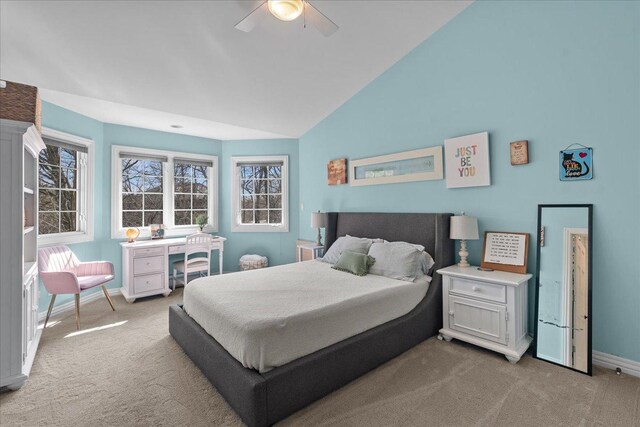 bedroom with a ceiling fan, baseboards, light carpet, and vaulted ceiling