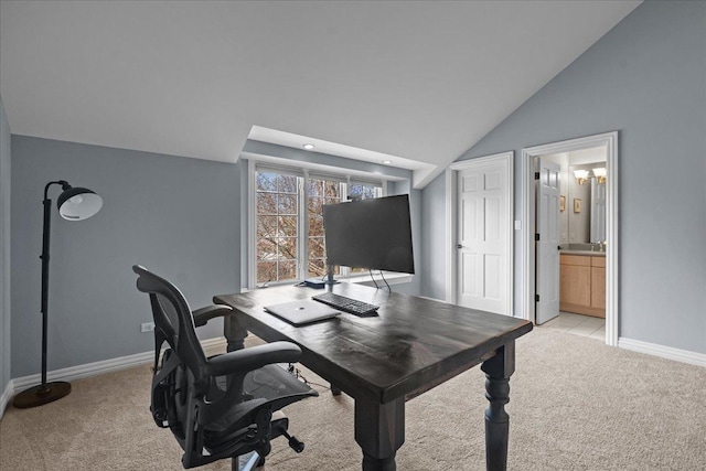 office space featuring baseboards, vaulted ceiling, and light colored carpet