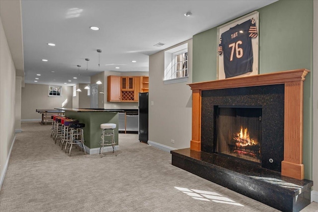 living room with baseboards, a dry bar, and light carpet