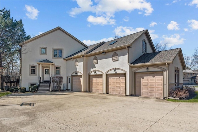 traditional-style home with an attached garage, roof with shingles, stucco siding, and driveway