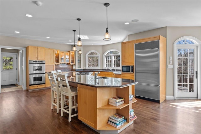 kitchen with recessed lighting, a sink, a kitchen island with sink, and stainless steel appliances