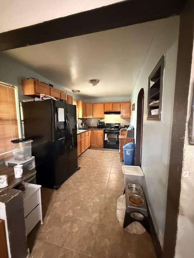 1004 Nowell Ave, Joliet, IL 60433 - kitchen featuring arched walkways, black appliances, light tile patterned flooring, and under cabinet range hood