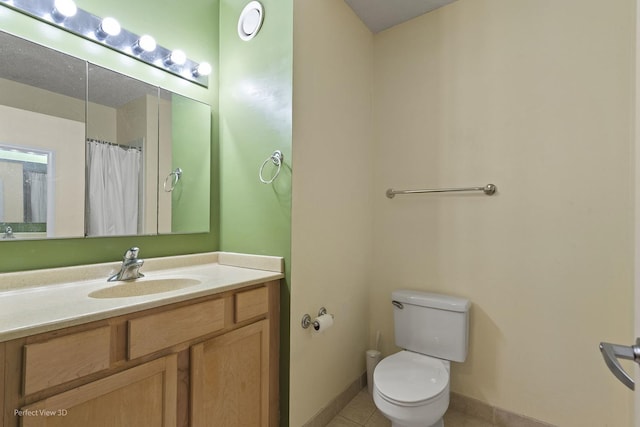 bathroom with tile patterned floors, baseboards, vanity, and toilet