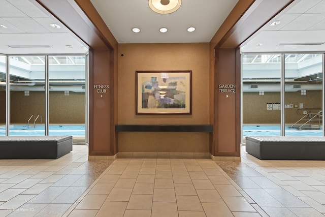 hallway with light tile patterned floors, baseboards, and recessed lighting