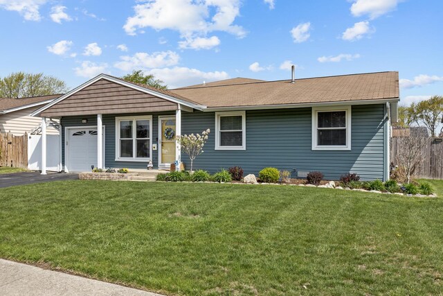 single story home with a garage, a front lawn, aphalt driveway, and fence