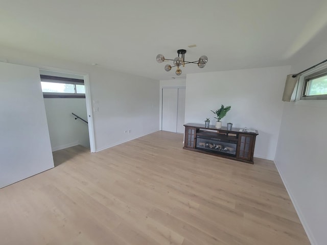 1076 Cernan Ct, Elk Grove Village, IL 60007 - unfurnished room featuring plenty of natural light, light wood finished floors, a chandelier, and baseboards