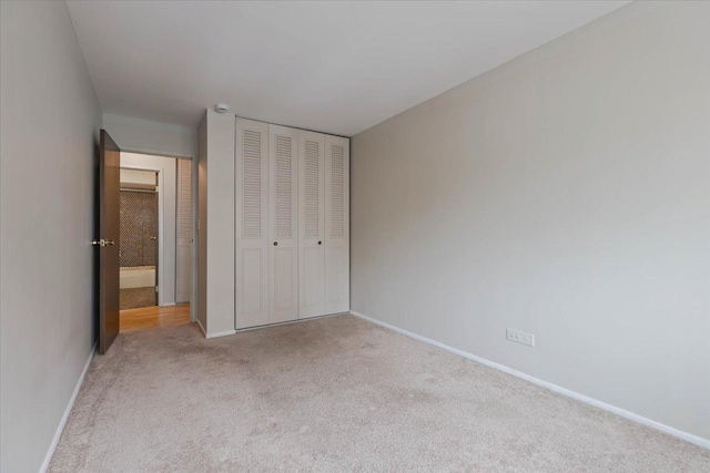 unfurnished bedroom with carpet flooring, a closet, and baseboards