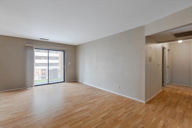 unfurnished room featuring baseboards, light wood-style floors, and visible vents