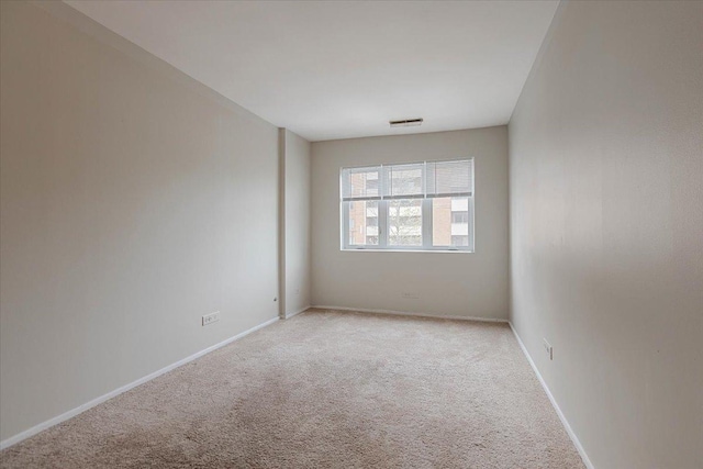 unfurnished room with light colored carpet, visible vents, and baseboards