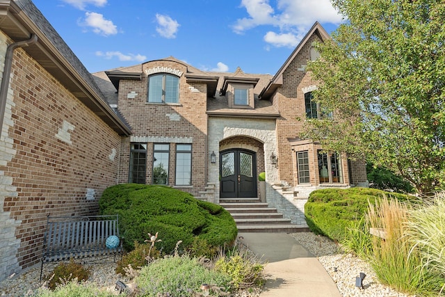 property entrance featuring french doors and brick siding