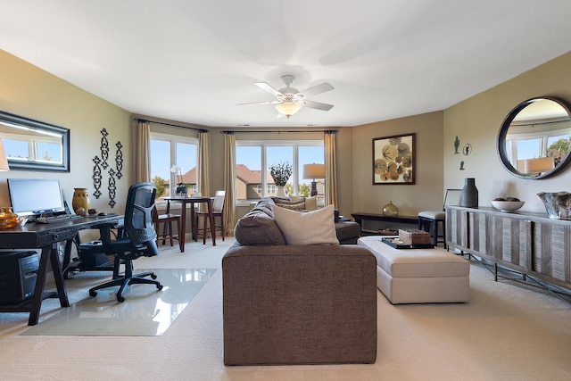 living room featuring plenty of natural light, a ceiling fan, and light carpet