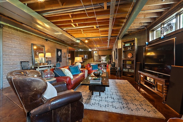 living area featuring finished concrete flooring and wooden walls