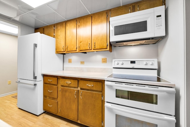2900 Maple Ave Unit 5A, Downers Grove, IL 60515 - kitchen with white appliances, brown cabinetry, light wood finished floors, and light countertops
