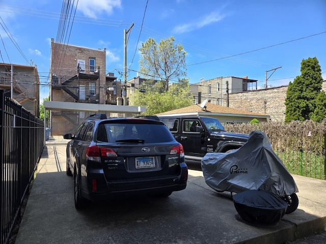 view of vehicle parking featuring fence
