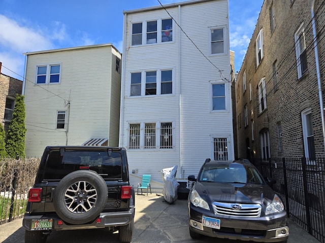 rear view of house featuring fence