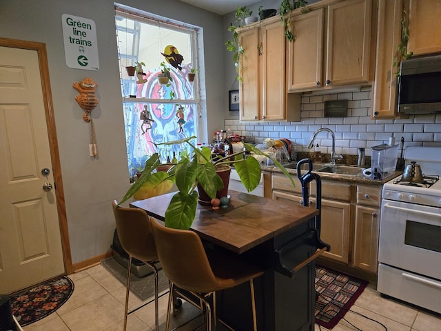 kitchen featuring wood counters, stainless steel microwave, white range with gas cooktop, and light tile patterned flooring