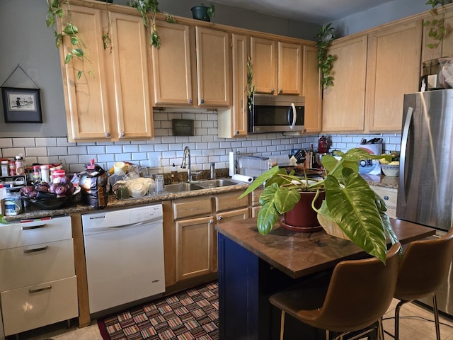 kitchen featuring a sink, light brown cabinetry, stainless steel microwave, and dishwasher