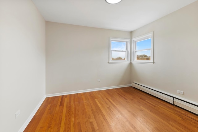 spare room with light wood-style floors, baseboards, and baseboard heating