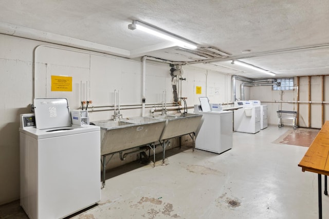 shared laundry area featuring washing machine and clothes dryer and a sink