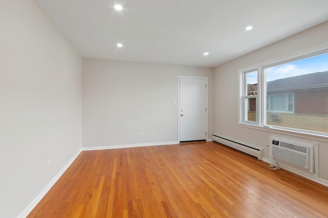 empty room with light wood-style floors, baseboards, a baseboard heating unit, and recessed lighting