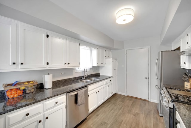 kitchen featuring a sink, appliances with stainless steel finishes, white cabinets, and light wood-style flooring