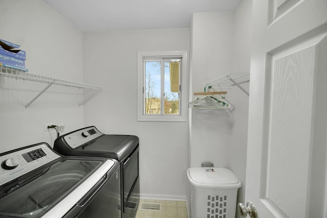 clothes washing area featuring washer and dryer, laundry area, and baseboards