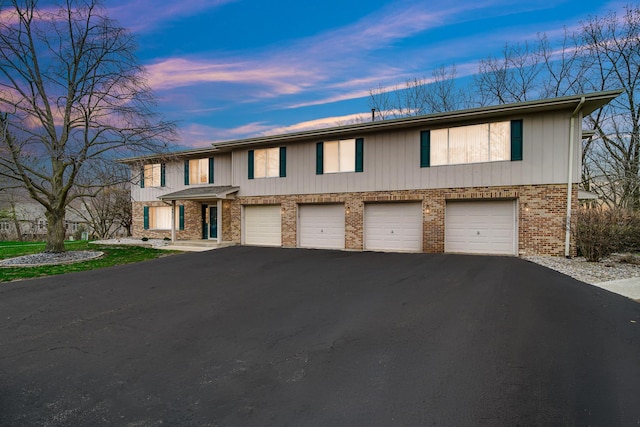 view of front of house featuring brick siding, driveway, and a garage