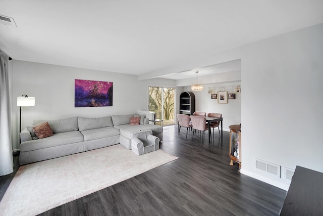 living room featuring baseboards, visible vents, and dark wood-style floors