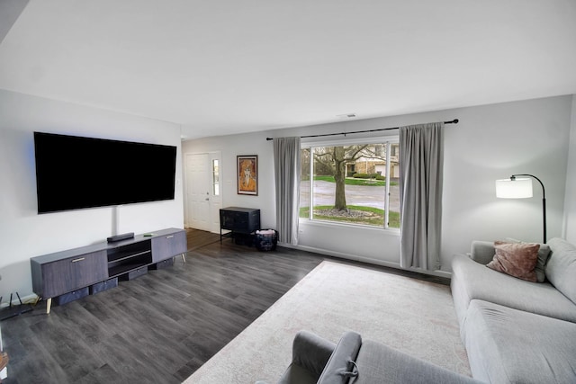 living area with baseboards and dark wood finished floors