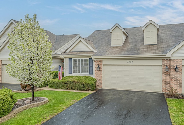 1207 E Oakwood Dr Unit 1207, Fox Lake, IL 60020 - view of front of house with a shingled roof, aphalt driveway, a garage, brick siding, and a front yard