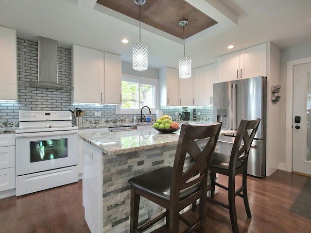 10847 Carpenter St, Mokena, IL 60448 - kitchen with wall chimney range hood, white range with electric stovetop, stainless steel refrigerator with ice dispenser, a tray ceiling, and dark wood-style floors
