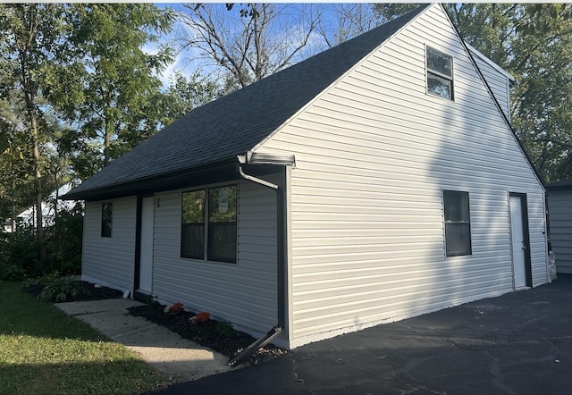 view of property exterior with a shingled roof