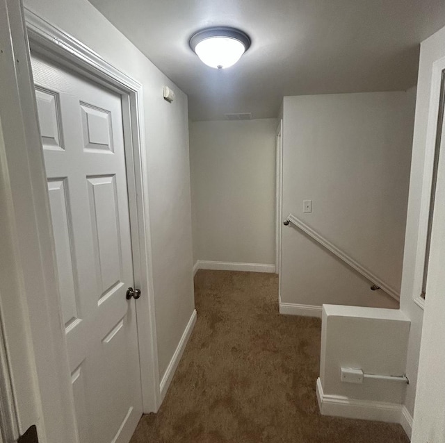 hallway with carpet flooring, baseboards, an upstairs landing, and visible vents