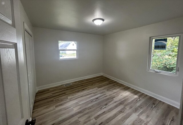 interior space with baseboards, a closet, wood finished floors, and visible vents