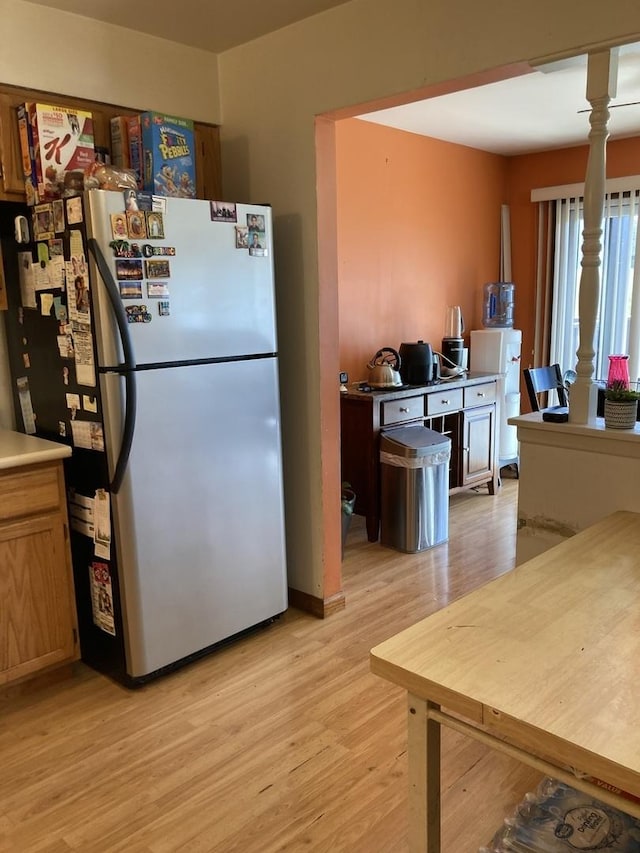 kitchen with freestanding refrigerator and light wood-style floors