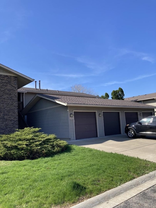 ranch-style home featuring a garage, a front yard, and concrete driveway