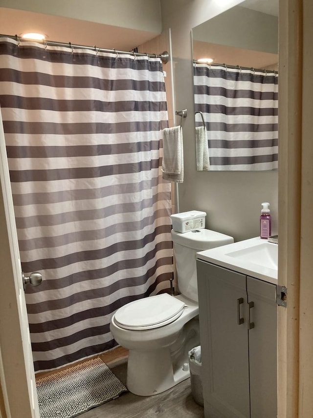 full bathroom with vanity, toilet, and wood finished floors