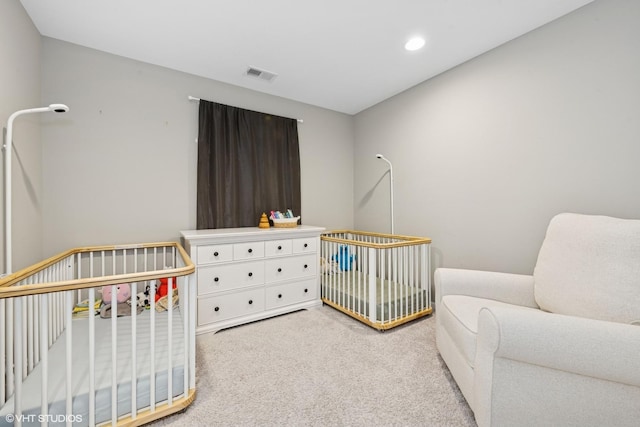 carpeted bedroom with visible vents, recessed lighting, and a nursery area