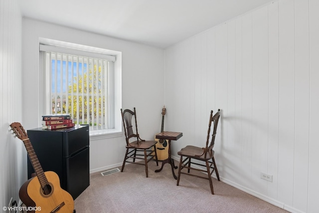 living area with carpet flooring, baseboards, and visible vents