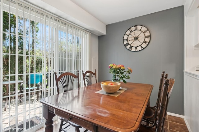 tiled dining room featuring baseboards