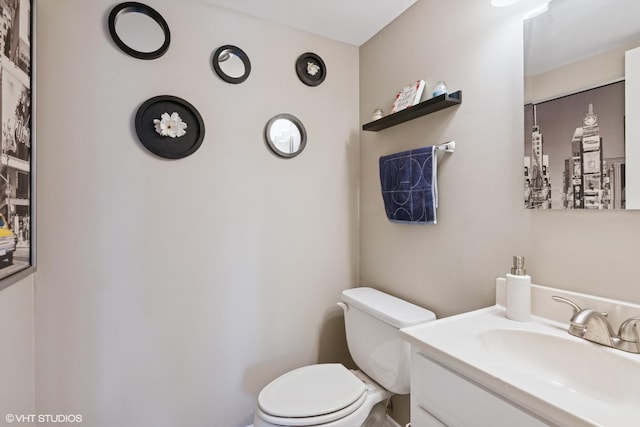 half bath featuring vanity and toilet