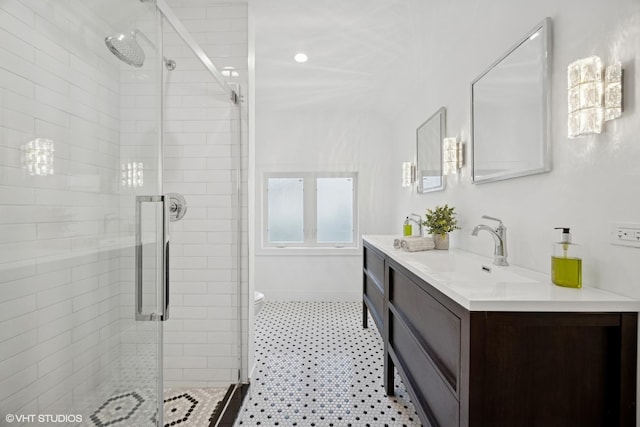bathroom featuring a stall shower, vanity, toilet, and baseboards